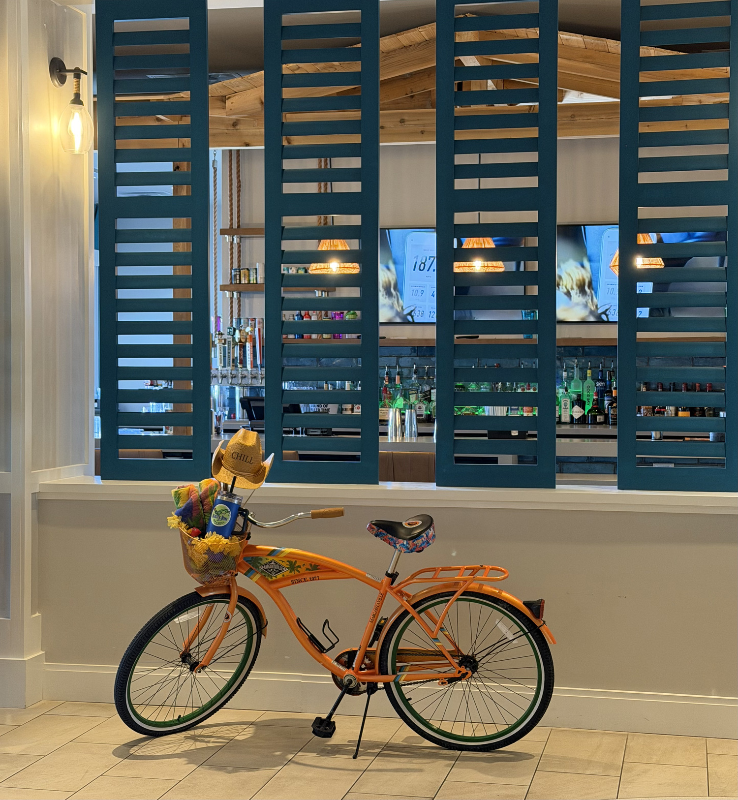 Orange bicycle in front of four blue shutters
